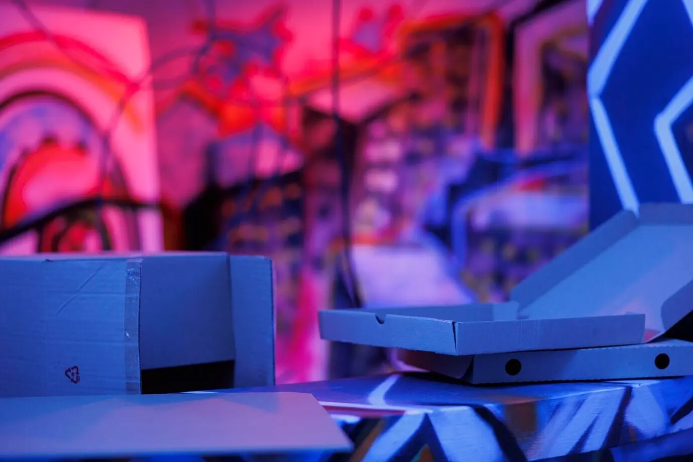 Afbrokkelend bouwwerk met paarse en roze lichten die gloeien in de duisternis van chaos en verval. Leeg, verlaten gebouw met graffitikunst op roestige muren, met een grunge-achtige uitstraling. Fluorescerend fel licht.